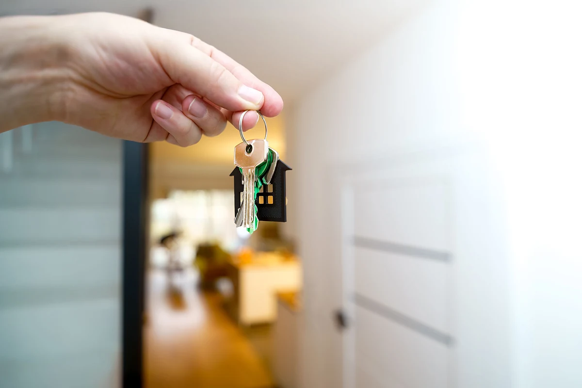 House keys, a calculator and funds representing investment-property financing